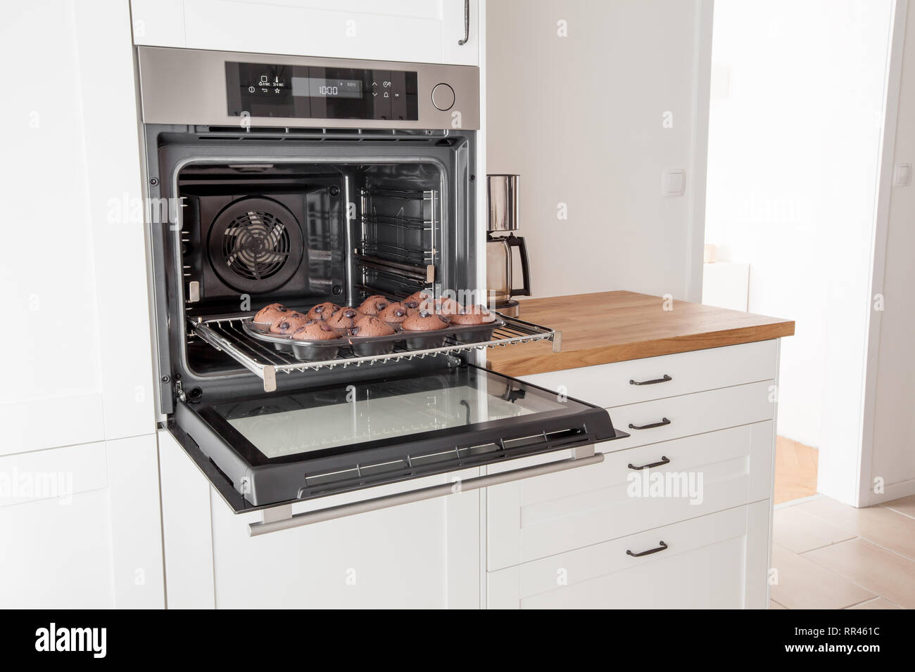 Muffins sur une plaque de cuisson au four dans une lumière blanche dans la cuisine de style moderne Banque D'Images