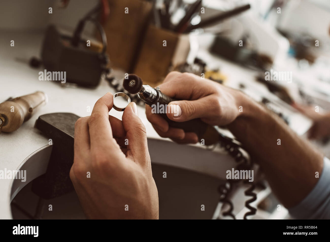 Mains de l'orfèvre à polir les bijoux en argent broche sur la roue de  polissage Photo Stock - Alamy