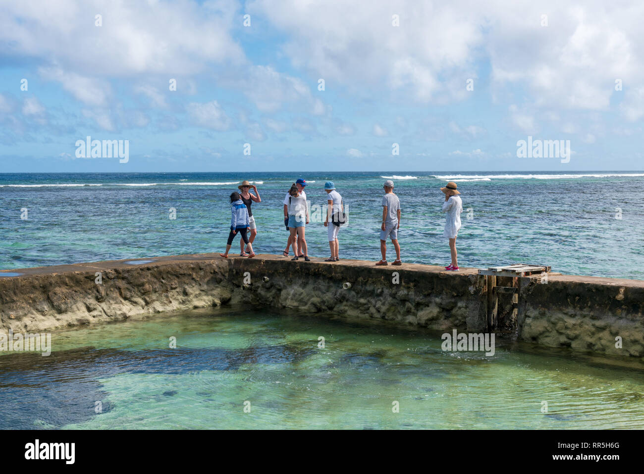 Nuku'alofa, Tonga -- le 10 mars 2018. Les touristes à pied le long de la partie supérieure d'un mur qui court forme un bassin océanique à Tonga. Banque D'Images