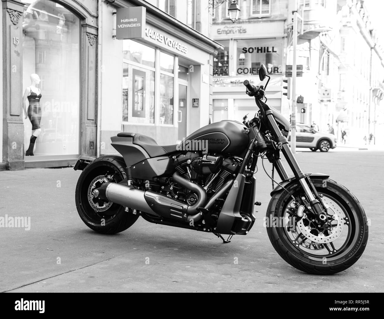Strasbourg, France - Dec 16, 2018 : stationné dans la ville toute nouvelle moto Harley Davidson moto avec magasins et bâtiments en arrière-plan noir et blanc Banque D'Images