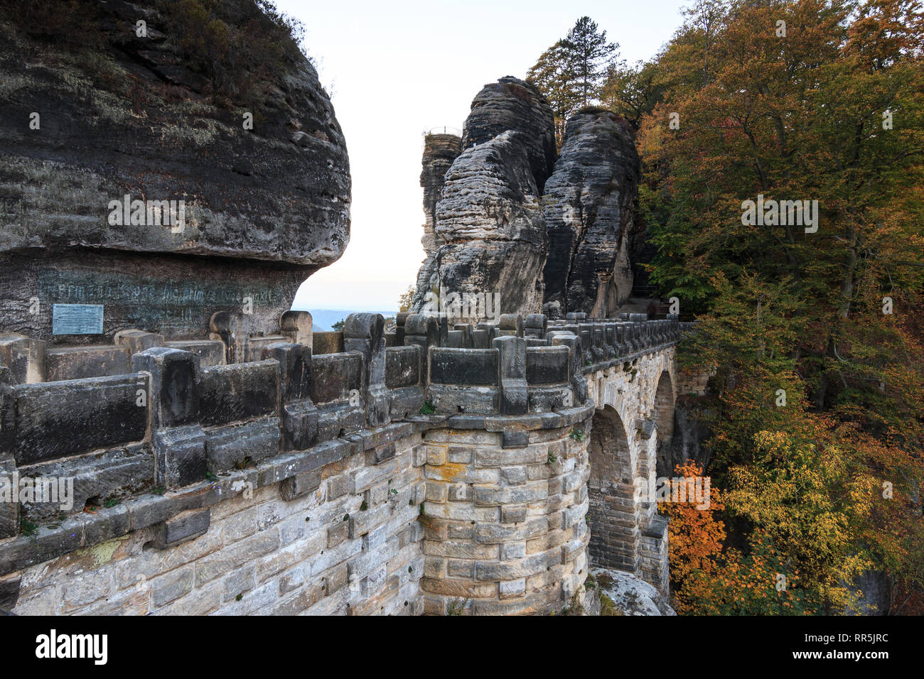 Vue de côté de la Bastei pont dans le parc national de la Suisse saxonne. Montagnes de grès de l'Elbe. Des formations rocheuses et arbres en automne. maçonnerie visible Banque D'Images