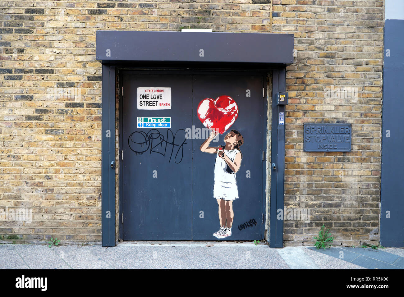 Fille avec coeur rouge sur un graffiti Love Street sur la construction à Stockwell Street à Brixton, dans le sud de Londres UK KATHY DEWITT Banque D'Images
