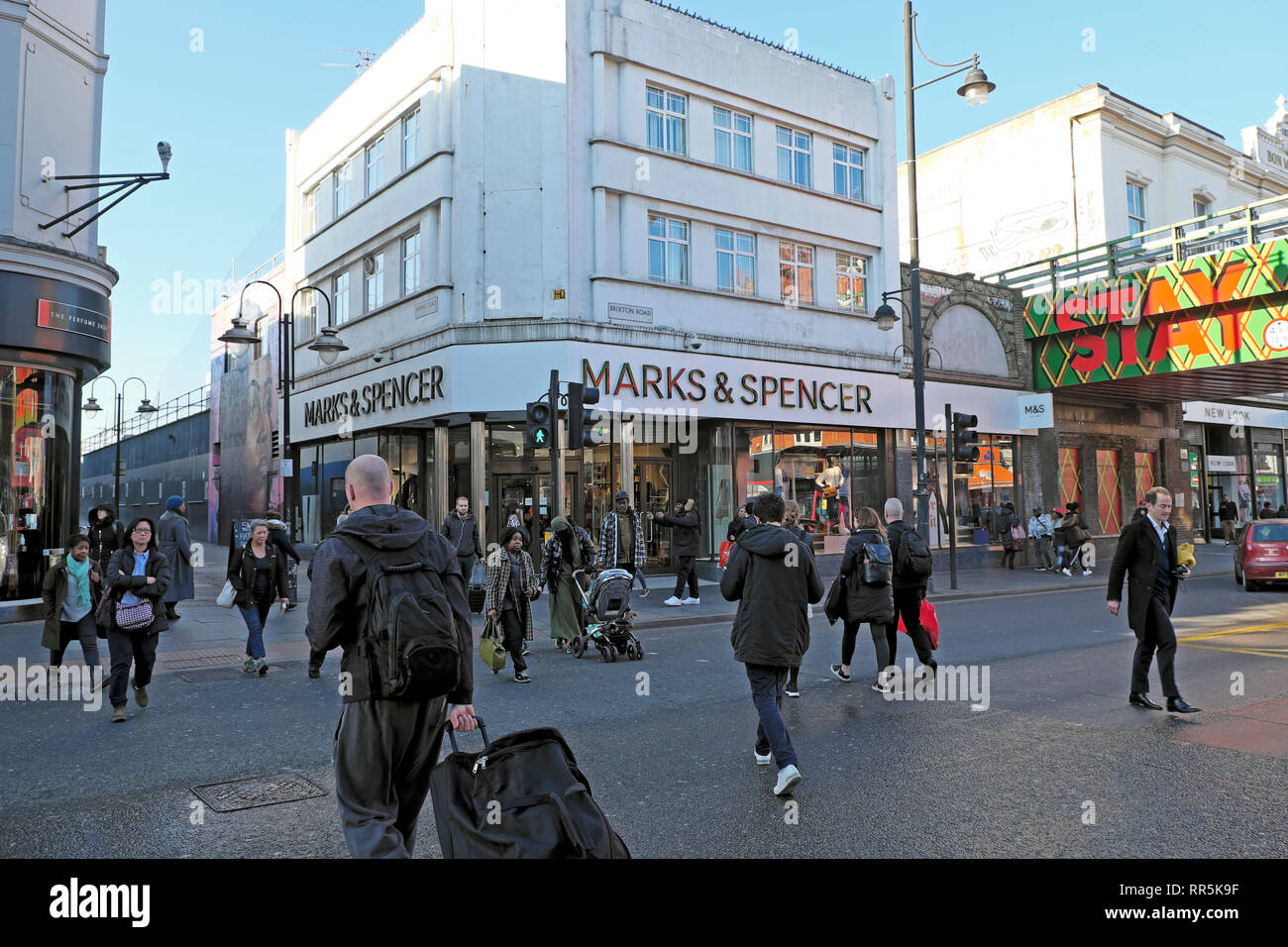 Les piétons qui traversent la route de shopping aux feux de circulation par Marks & Spencer store sur Brixton Road à Brixton, dans le sud de Londres UK KATHY DEWITT Banque D'Images