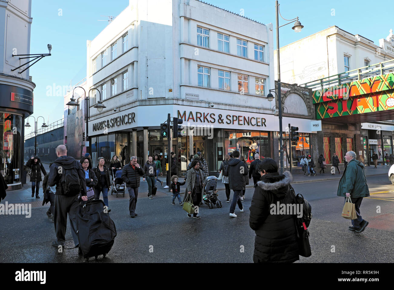Les piétons qui traversent la route de shopping aux feux de circulation par Marks & Spencer store sur Brixton Road à Brixton, dans le sud de Londres UK KATHY DEWITT Banque D'Images