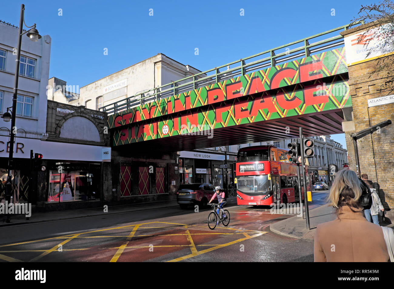 Séjour en signe de la paix sur le pont ferroviaire sur Brixton Road et des personnes, la circulation en street à Brixton, dans le sud de Londres SW9 England UK KATHY DEWITT Banque D'Images