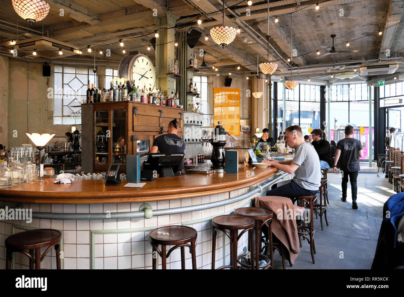 L'homme assis à la clientèle en utilisant un ordinateur portable dans un restaurant italien Canova Hall bar club à Brixton, dans le sud de Londres SW9 UK KATHY DEWITT Banque D'Images