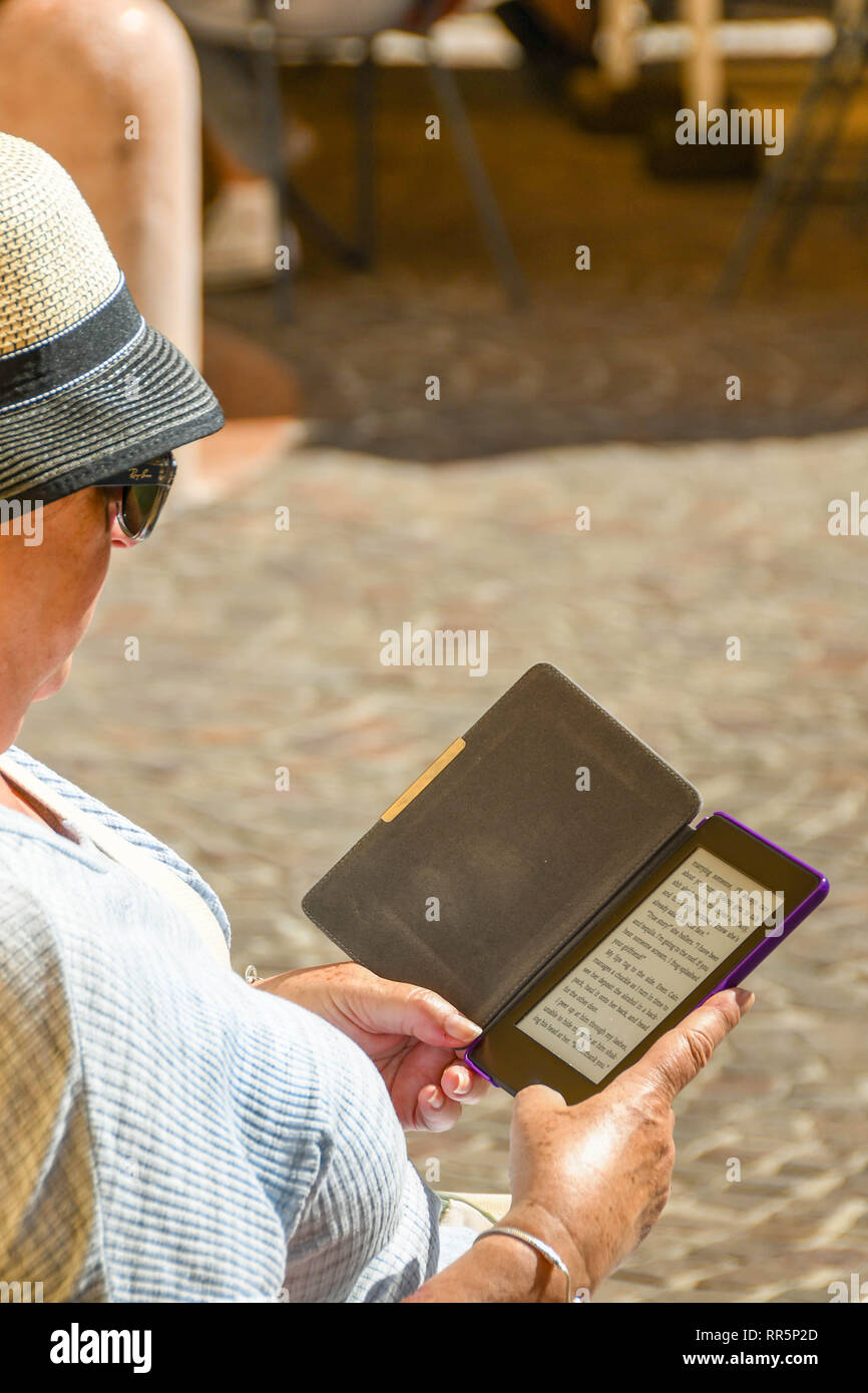GARDONE RIVIERA, ITALIE - Septembre 2018 : la lecture d'un roman sur un e-reader. Banque D'Images