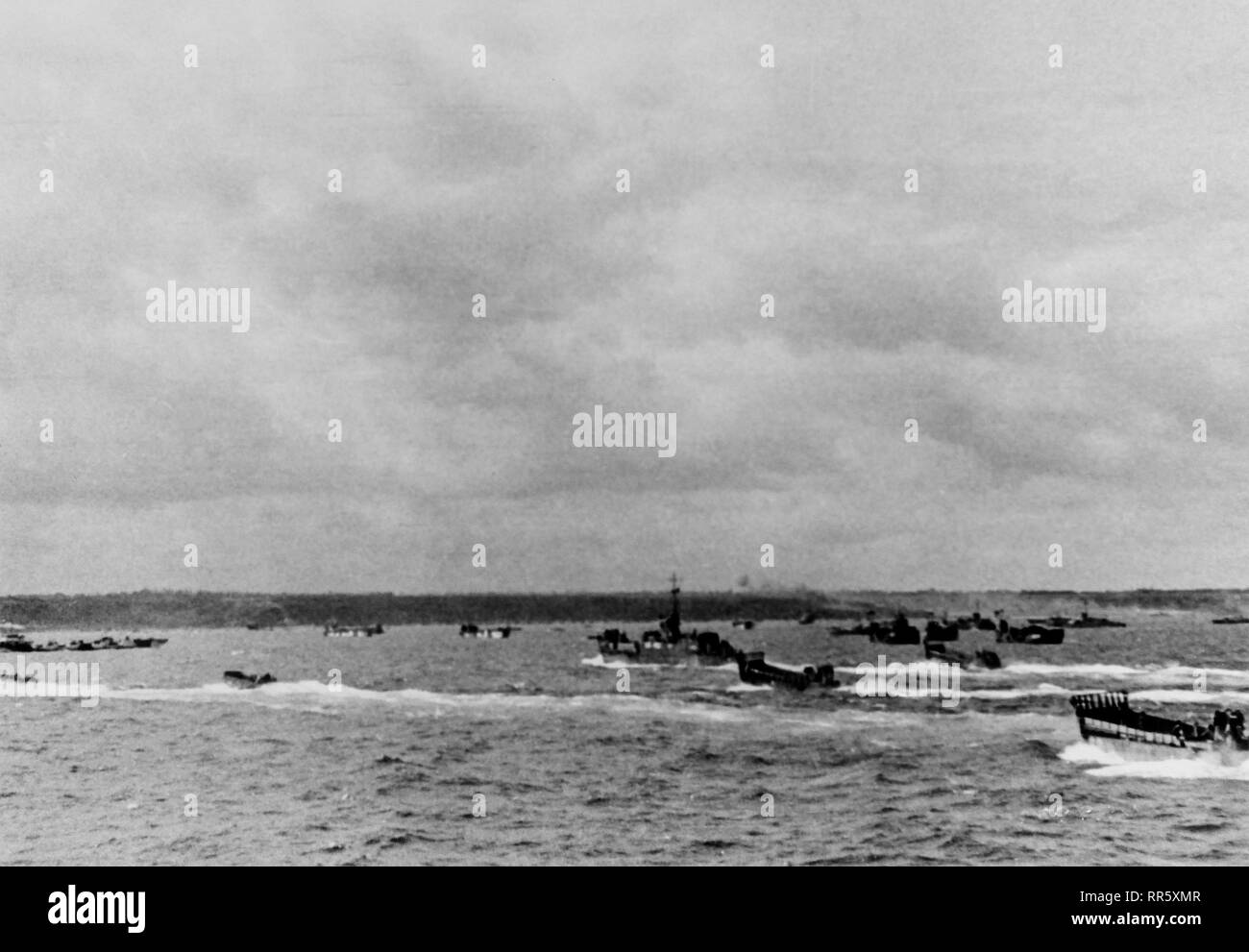 [CAPTION] l'origine des engins de débarquement d'Omaha Beach approche toutes tailles remplis de troupes d'assaut de la première vague à fouler le sol français. Normandie Juin 1944 Banque D'Images