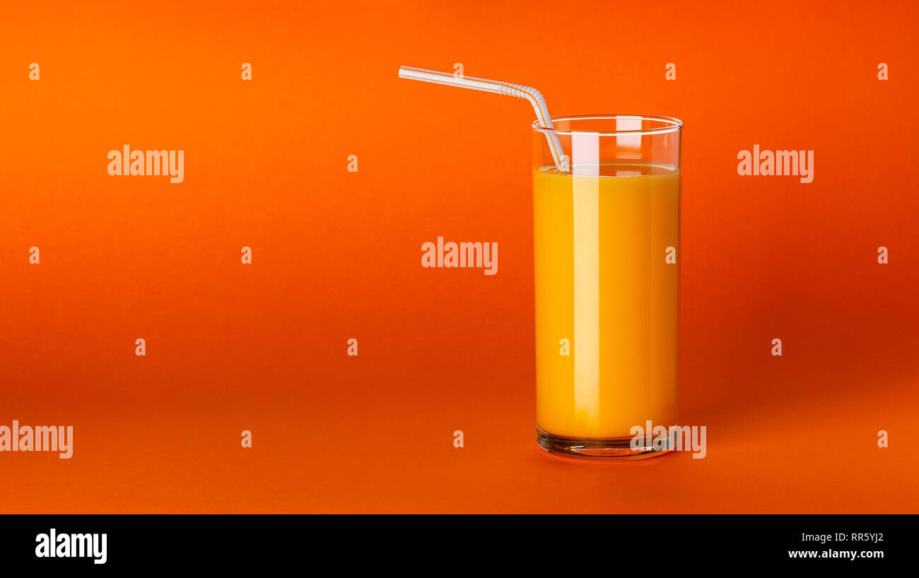 Un verre de jus d'orange sur fond orange with copy space Banque D'Images