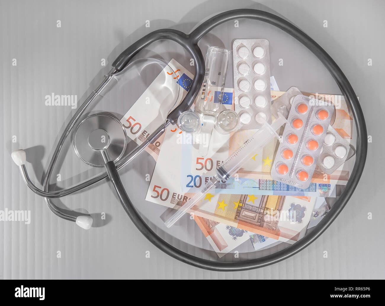 Billets médicaments seringue sur fond gris Banque D'Images