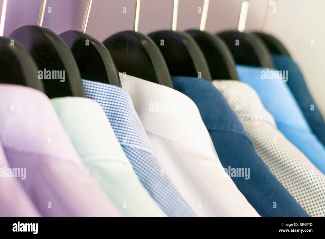 Plusieurs hommes chemises de différentes couleurs sur les supports. Selective focus Banque D'Images