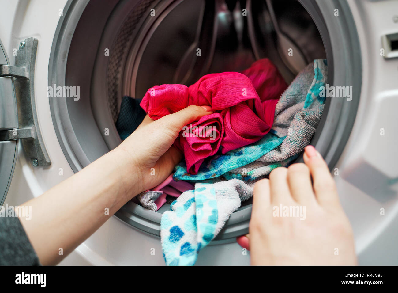 Image des femmes mains mettre les vêtements sales dans la machine à laver Banque D'Images