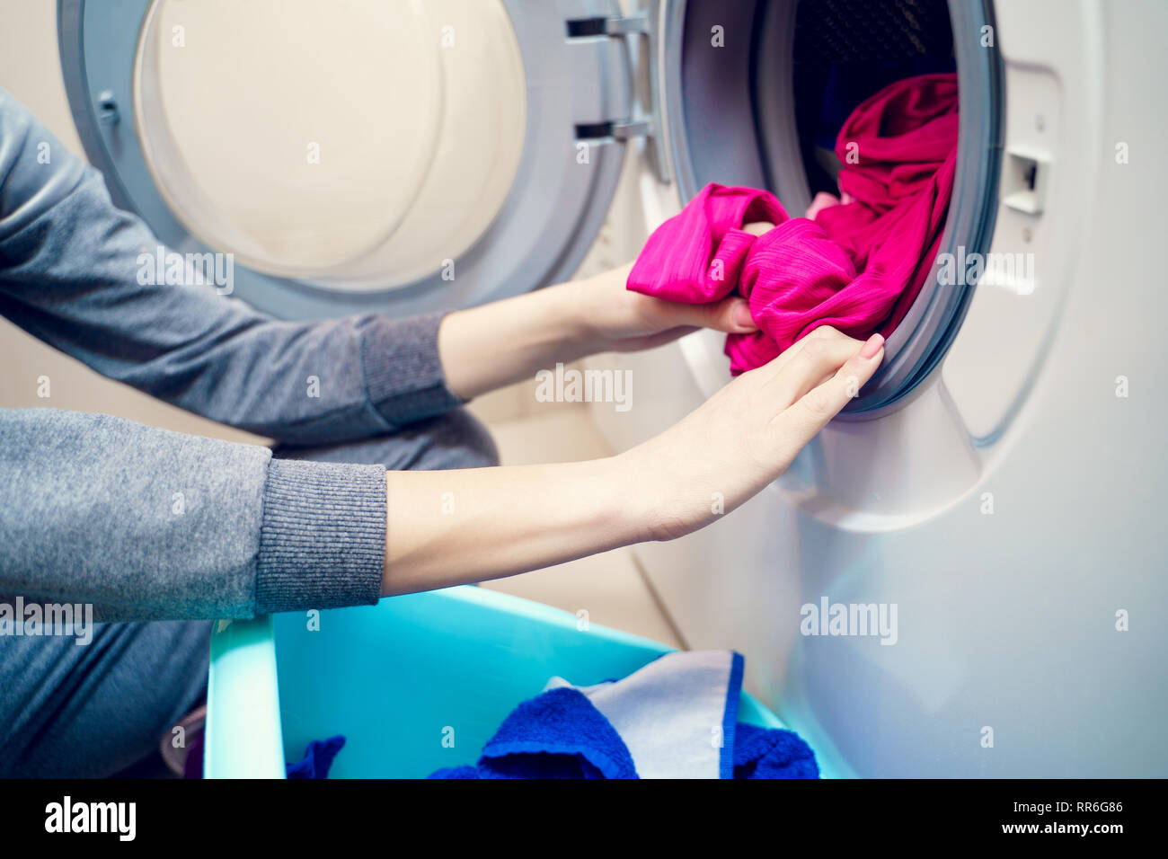 Photo de femmes mettre les vêtements sales dans la machine à laver Banque D'Images