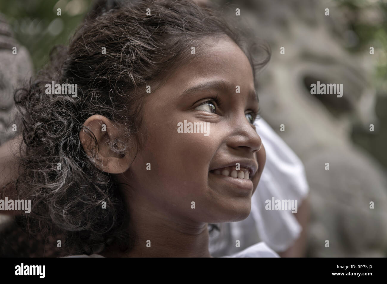 Une petite fille prend du temps hors de l'école du dimanche au Temple Bouddhiste Gangaramaya Colombo au Sri Lanka. Banque D'Images