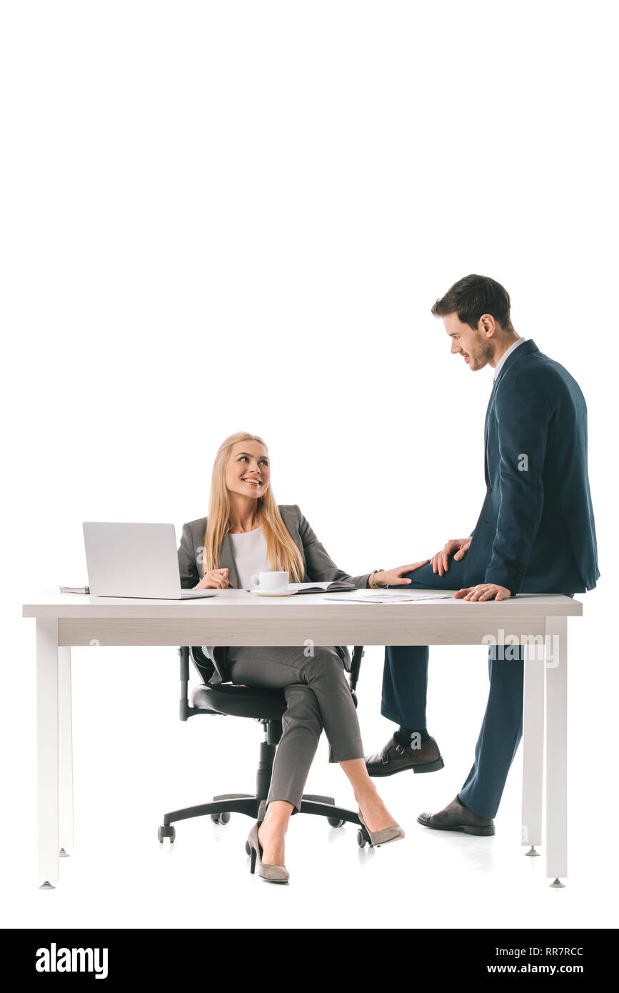 Beautiful smiling businesswoman flirter avec collègue masculin au lieu de travail avec ordinateur portable Banque D'Images