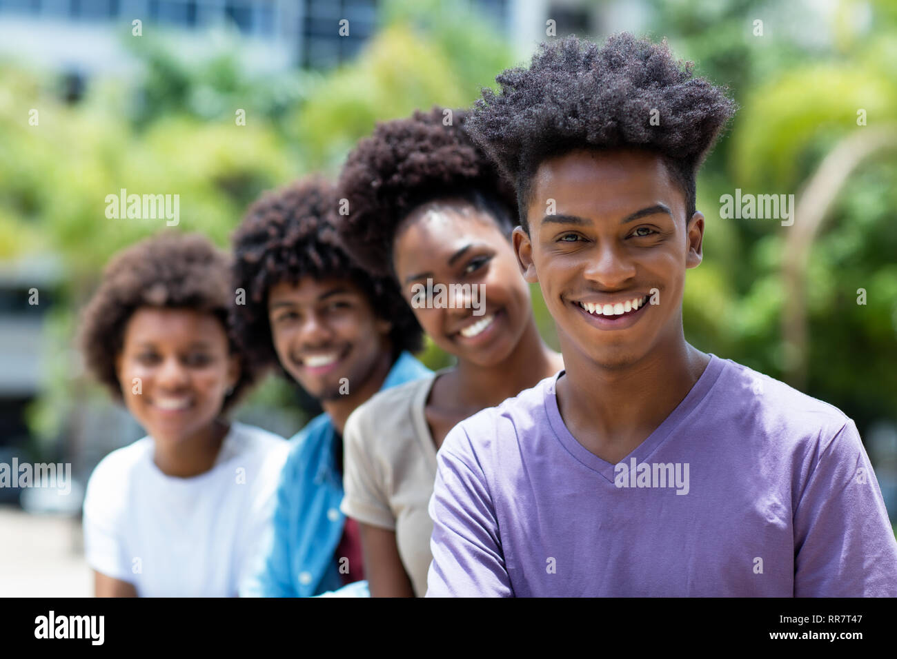Rire african american man avec groupe de jeunes adultes en ligne piscine en ville en été Banque D'Images