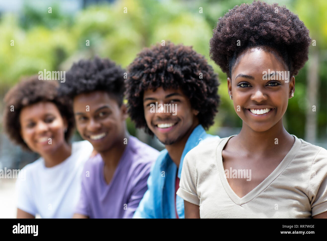 Rire african american woman avec groupe de jeunes adultes en ligne piscine en ville en été Banque D'Images