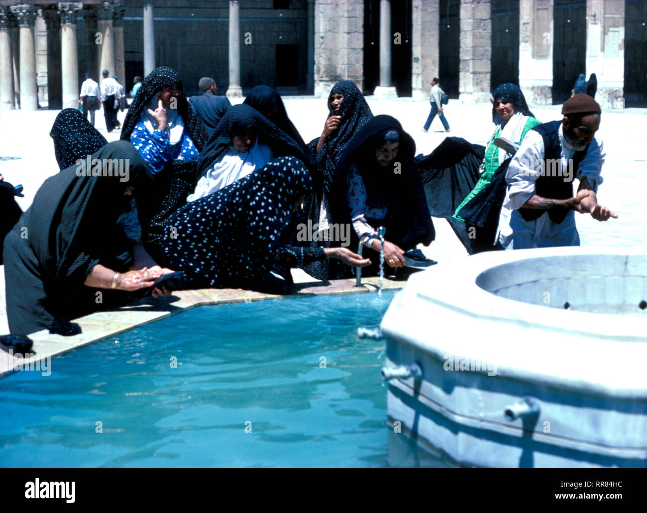Pèlerins chiites qui se lavent dans le réservoir dans la cour de la mosquée Omeyyade à Damas en Syrie, la mosquée date du VIIIe siècle et est un lieu de pèlerinage majeur au Moyen-Orient. Banque D'Images