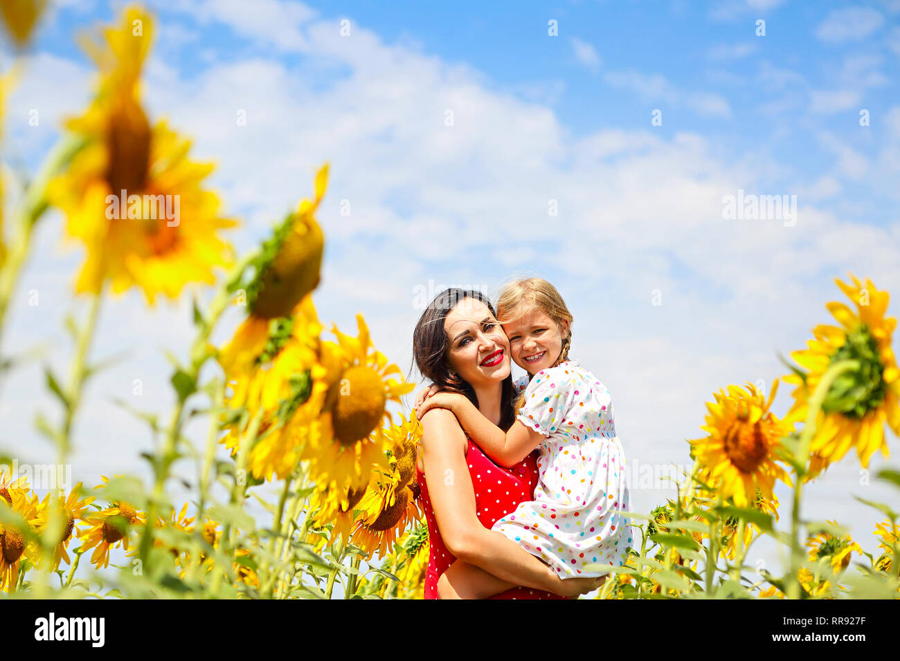 Heureuse mère et sa petite fille dans le champ de tournesol Banque D'Images