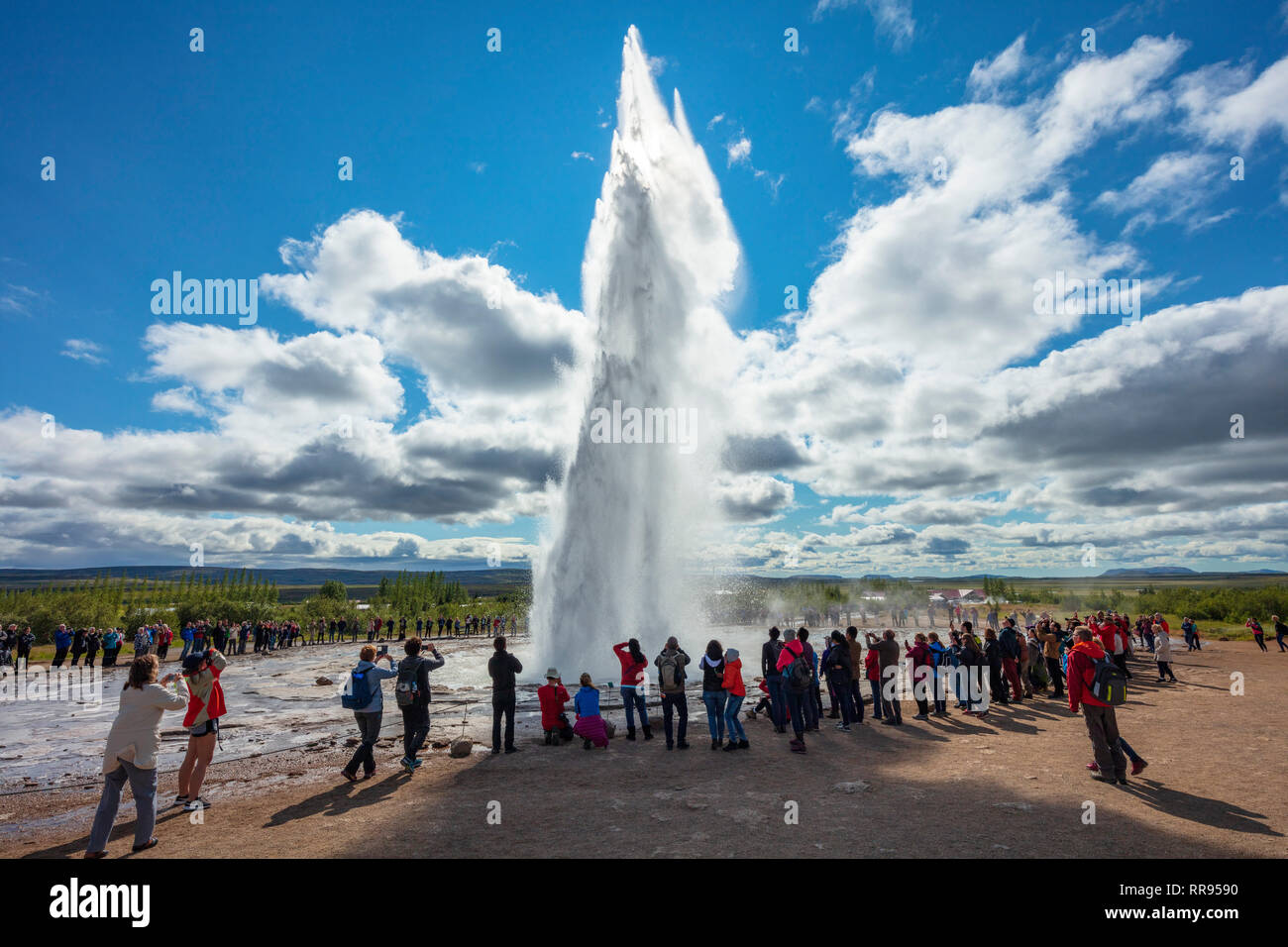 Les touristes regardant Strokkur geyser comme il éclate. Geysir, Sudhurland, Islande. Banque D'Images