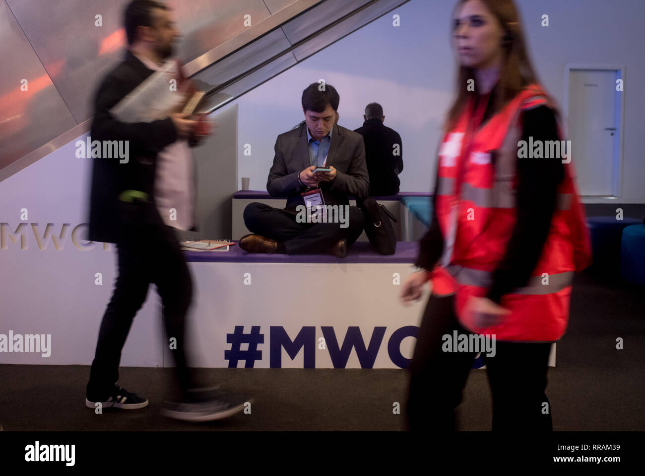 Barcelone, Catalogne, Espagne. Feb 25, 2019. Un préposé vérifie son téléphone mobile pendant le jour de l'ouverture de la GSMA Mobile World Congress 2019 à Barcelone, l'événement mondial le plus important sur la communication à partir d'appareils mobiles apportant togeteher les principales entreprises et les derniers développements dans le secteur. Crédit : Jordi Boixareu/ZUMA/Alamy Fil Live News Banque D'Images