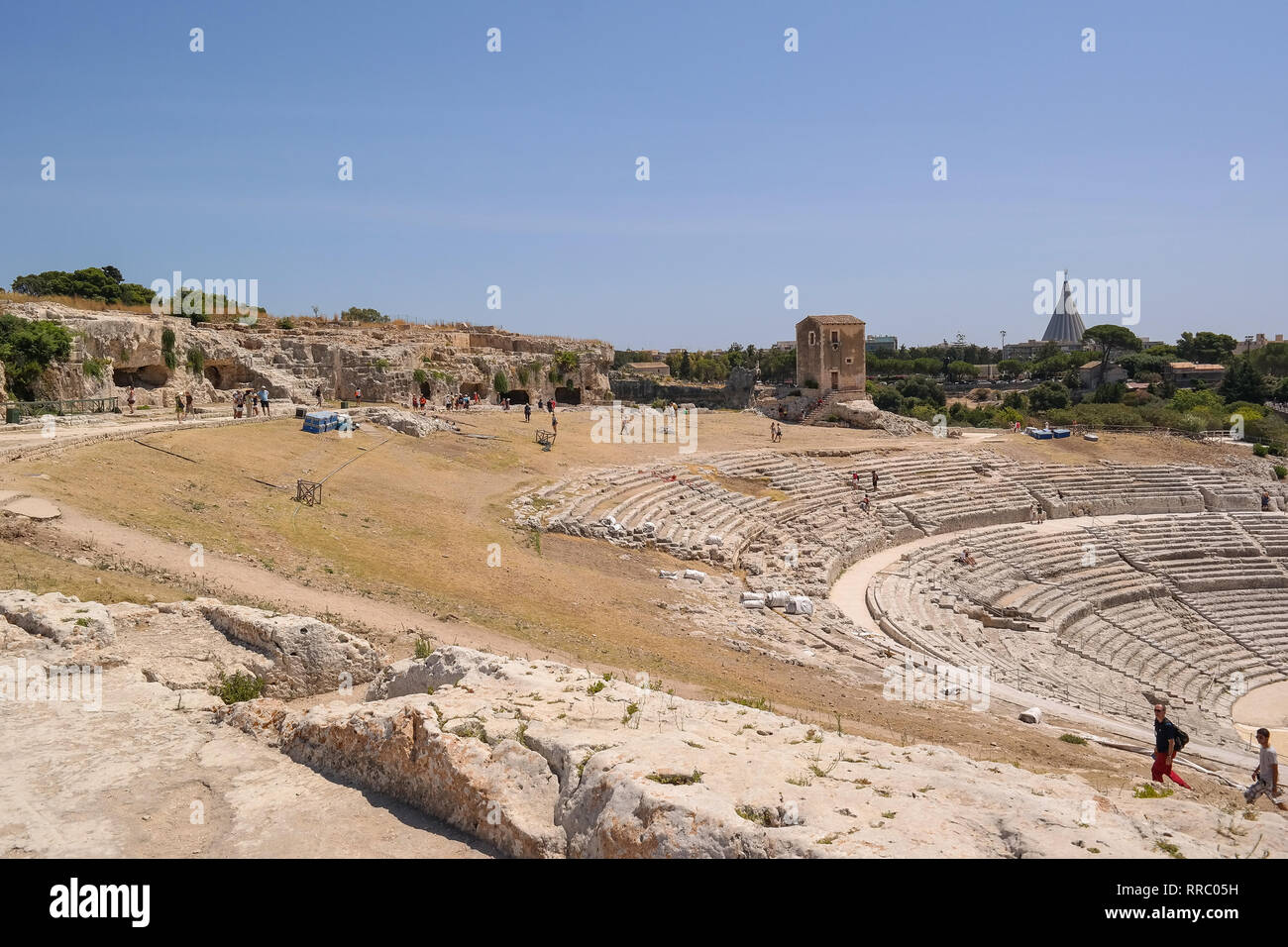 Ruines du théâtre grec antique de Syracuse, parc archéologique de jolie forme et Santuario della Madonna delle Lacrime est visible au loin. Banque D'Images