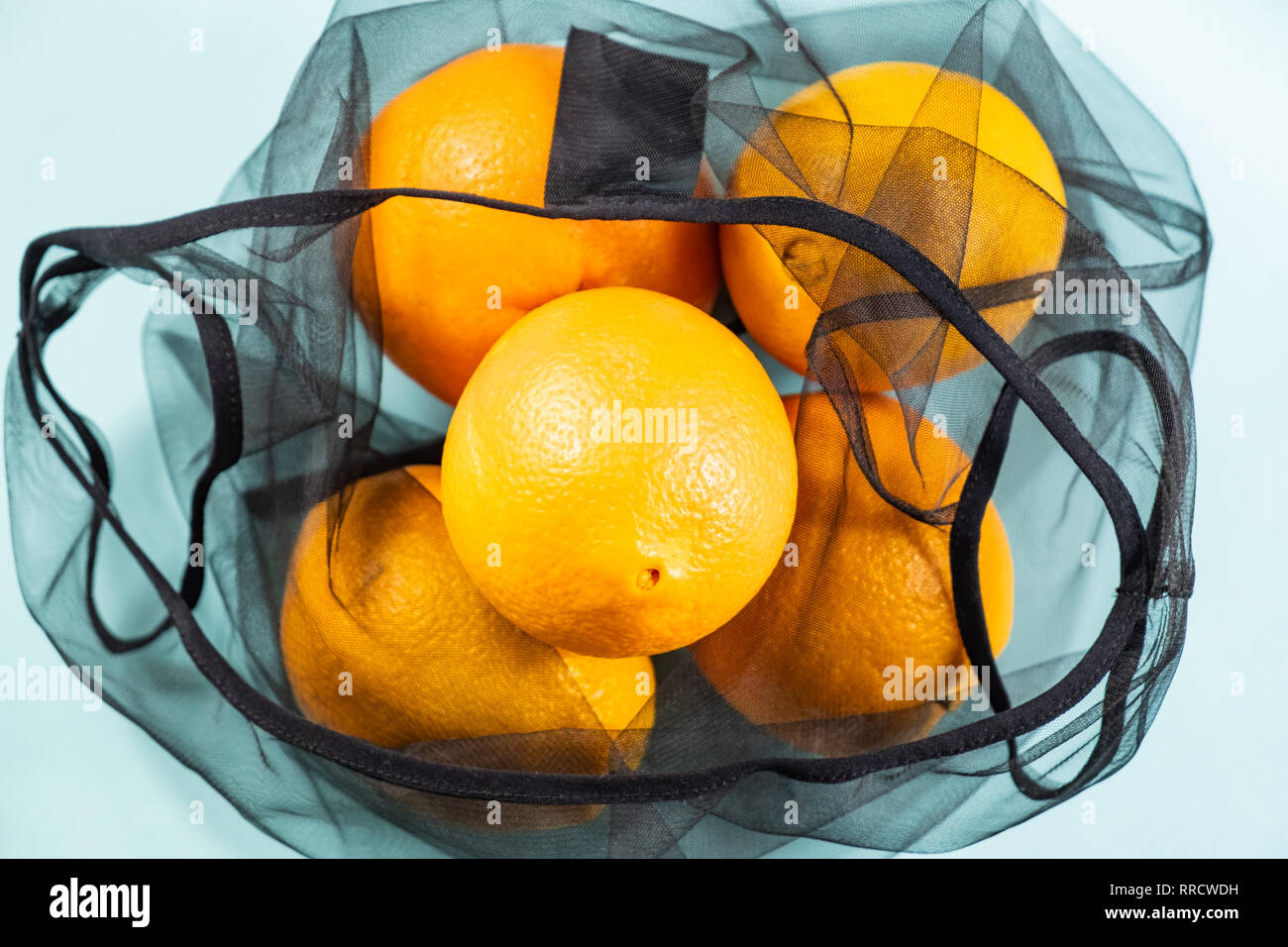 Vue de dessus d'oranges dans un sac réutilisable, string. Concept d'emballage écologique durable : faire les courses avec un sac multi-usage pour réduire l'empreinte écologique Banque D'Images