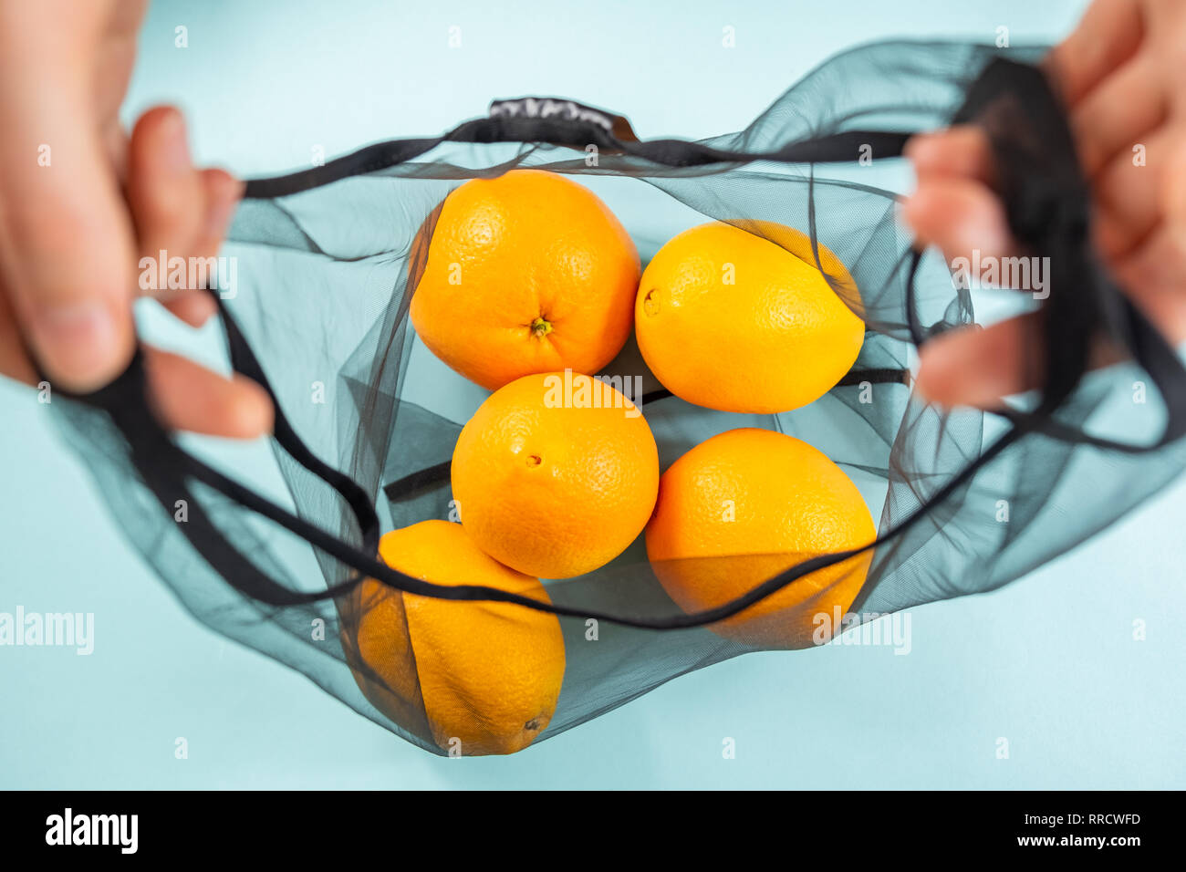 Vue de dessus d'oranges dans un sac réutilisable, string. Concept d'emballage écologique durable : faire les courses avec un sac multi-usage pour réduire l'empreinte écologique Banque D'Images