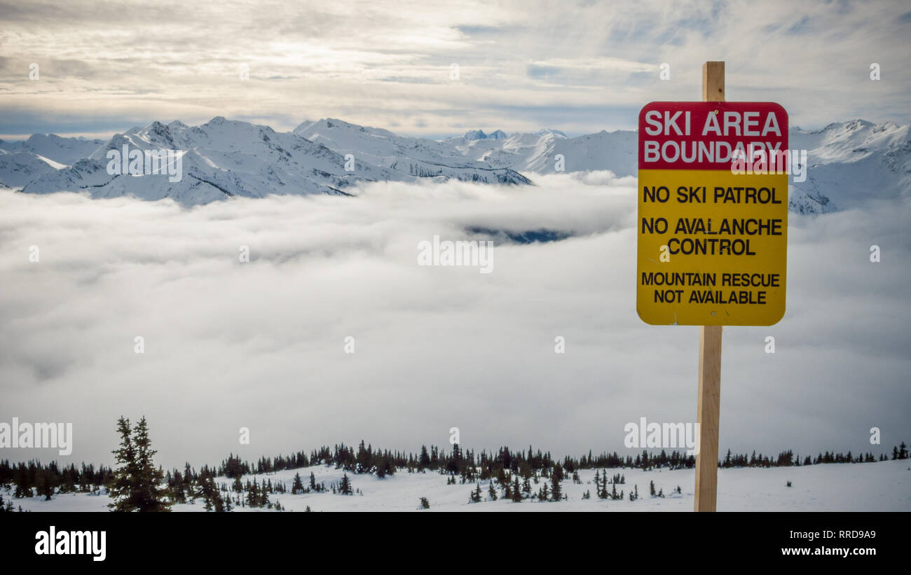 Vue pittoresque du pic de la montagne dans les nuages et avertissement de limite de la zone de ski mots au Canada Banque D'Images