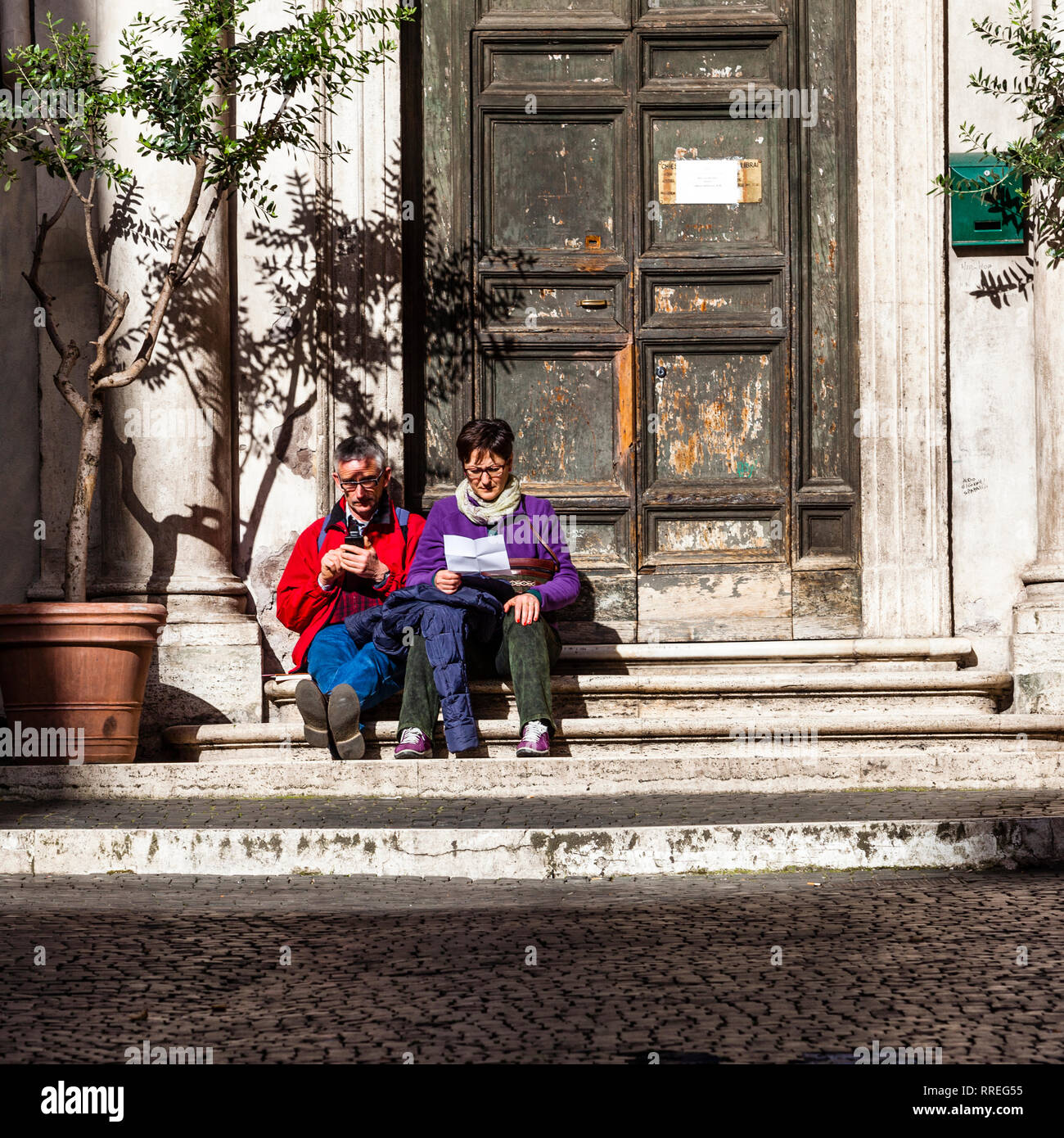 Couple sitting in Rome le lecture strairs Banque D'Images