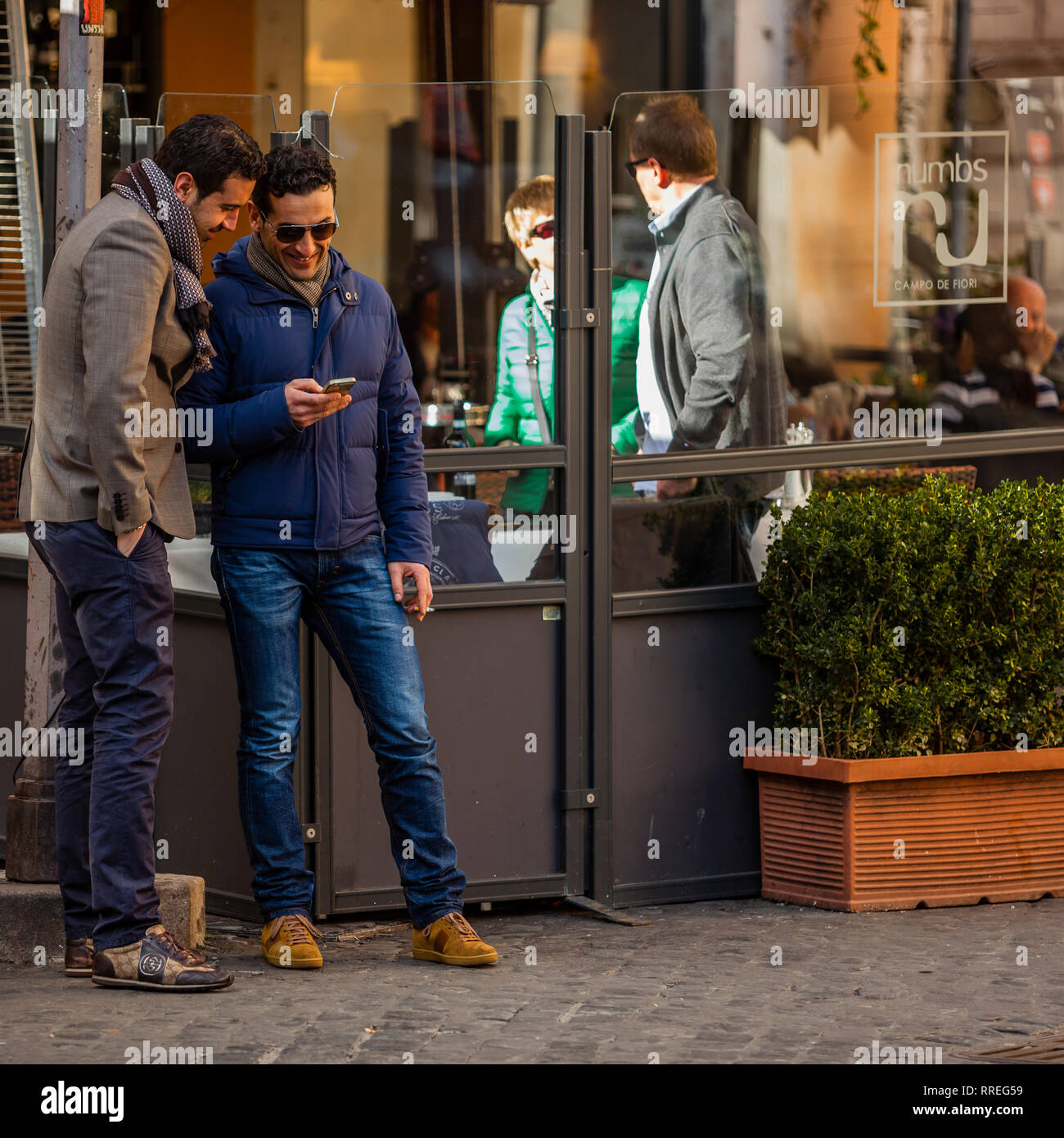 Les hommes à Rome à la recherche de téléphone cellulaire Banque D'Images