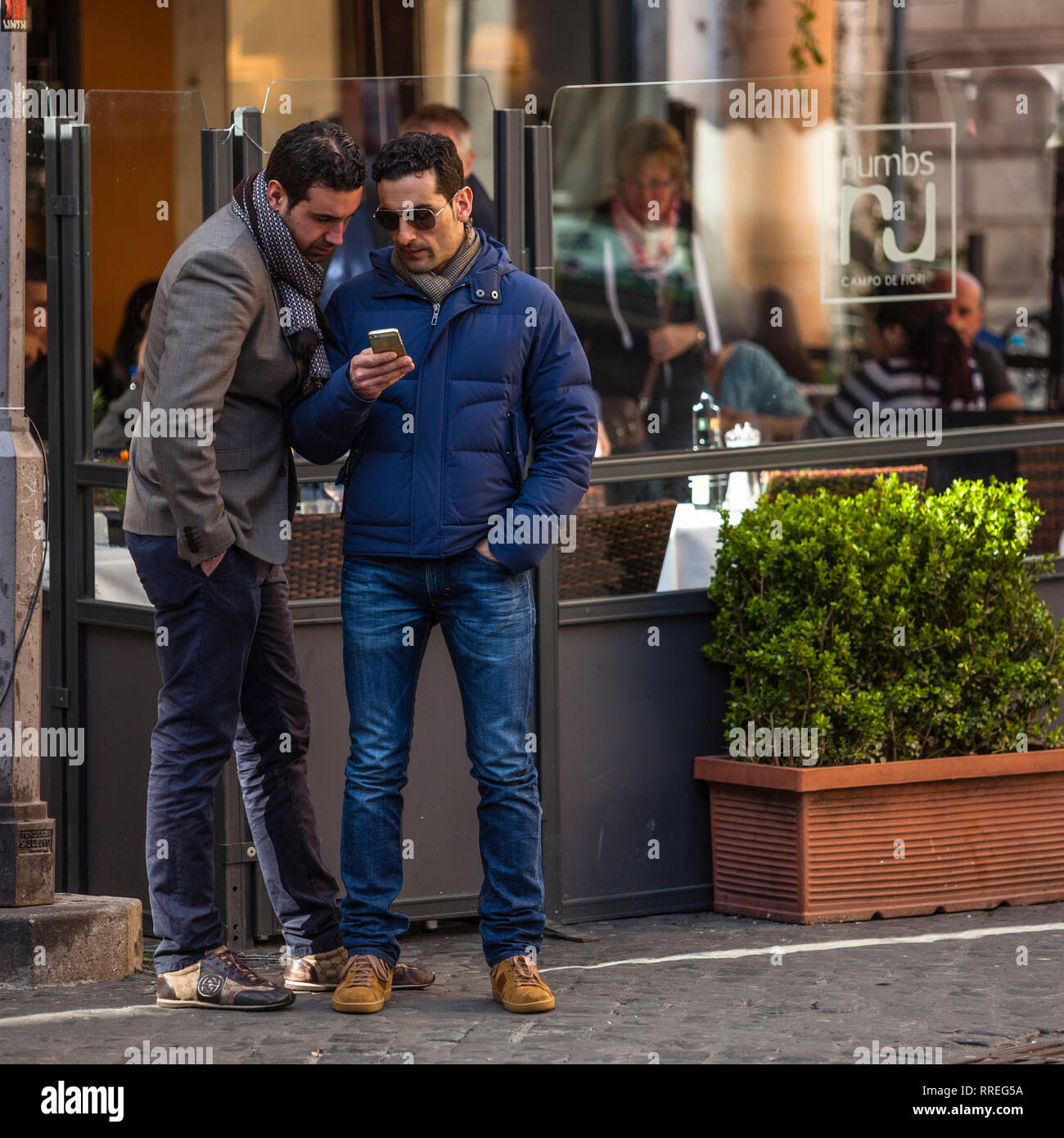 Les hommes à Rome à la recherche de téléphone cellulaire Banque D'Images
