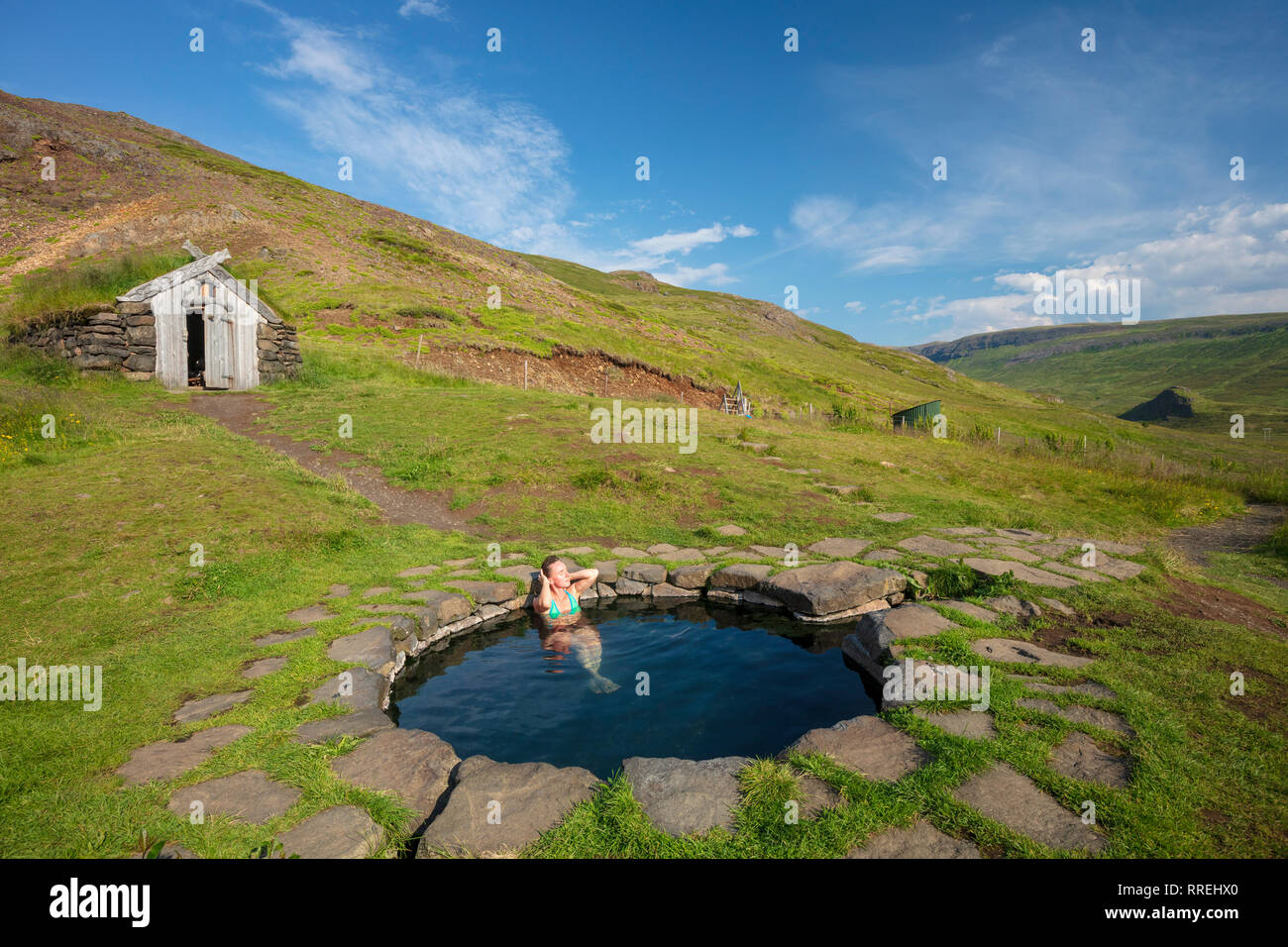 Woman bathing in Gudrunarlaug piscine géothermique. Laugar, Islande de l'ouest, Sælingsdalur. Banque D'Images