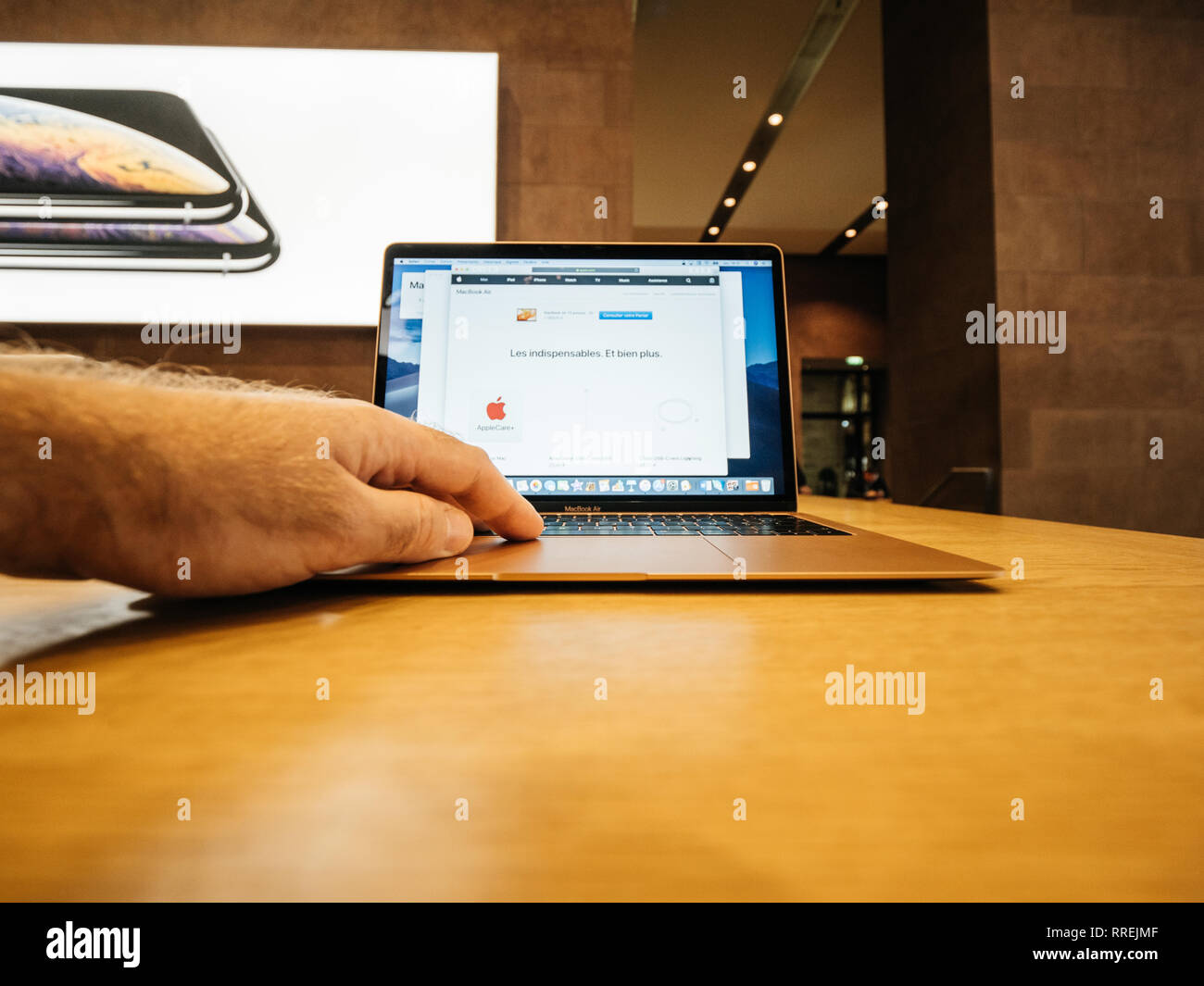 PARIS, FRANCE - Nov 8, 2018 : Man working on the new Apple MacBook Air ordinateur portable léger avec écran Retina et nouveau CPU en utilisant le site Web d'Apple Banque D'Images