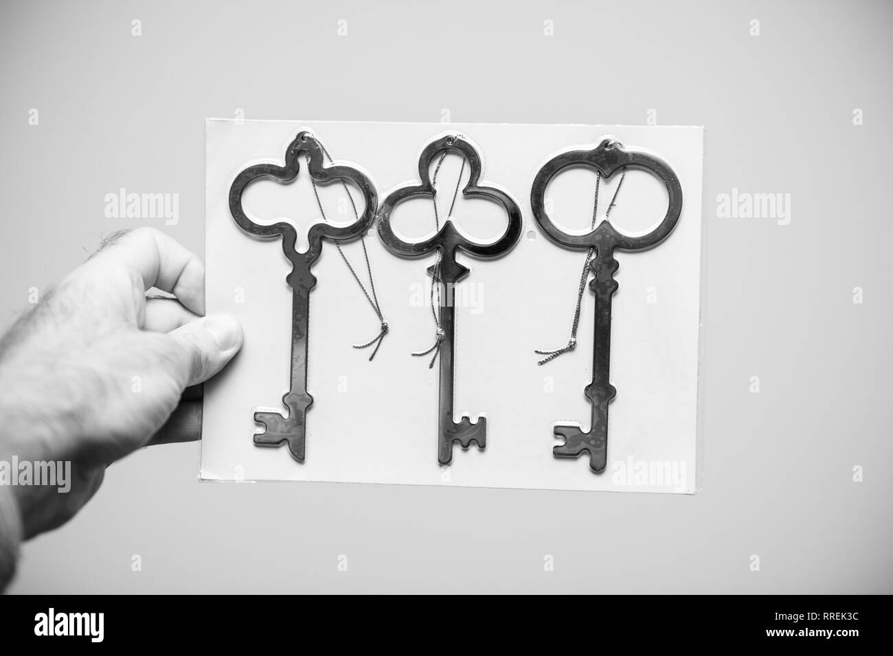 Man holding against white background d'un jeu de trois clés ancienne vintage noir et blanc Banque D'Images