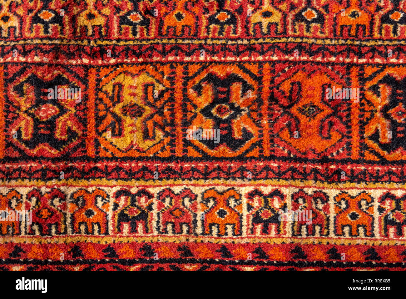 Détails d'un ornement vintage tapis persan de rouge vif, brun, jaune et noir. Motif textile ou d'arrière-plan Banque D'Images