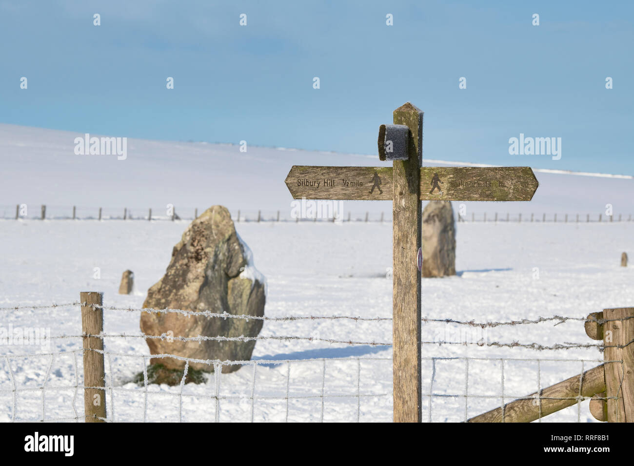 Silbury Hill walking panneau dans la neige de l'hiver juste après le lever du soleil. Avebury, dans le Wiltshire, Angleterre Banque D'Images