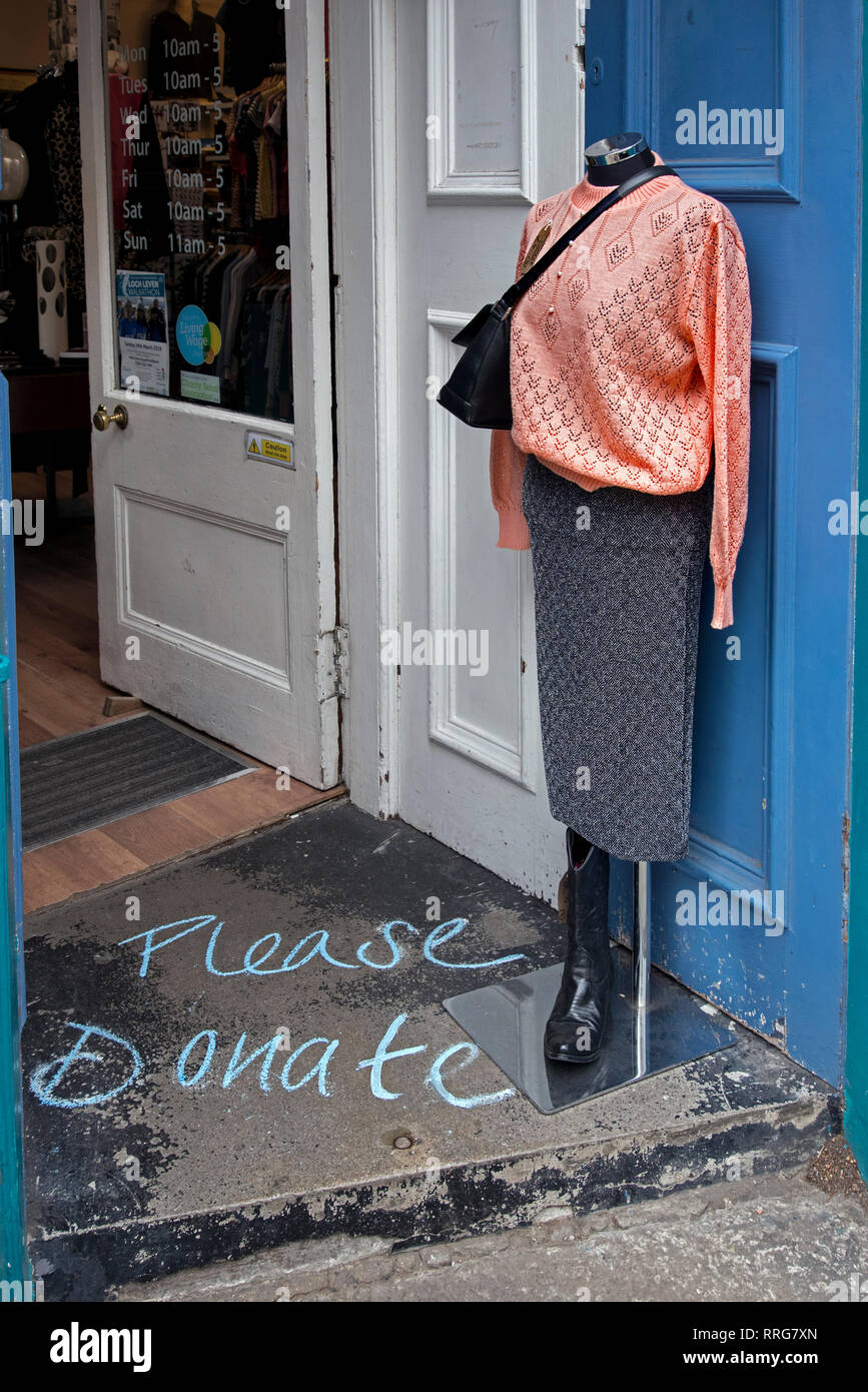 Mannequin à la porte d'un shop chariry à Stockbridge, Édimbourg, avec les mots "s'il vous plaît un don" à la craie sur le sol. Banque D'Images