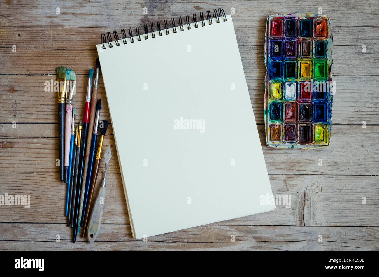 Artiste Créateur de travail télévision lay, immersive. Vue de dessus sur table avec carnet vierge, pinceaux et palettes de colorant. L'Art, atelier, peinture, dessin, Banque D'Images