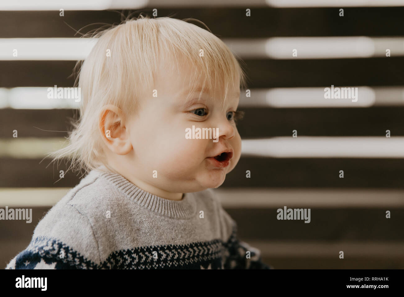 Cute Adorable petite blonde tout-petit enfant rire, s'amuser, et faire face à l'extérieur à la maison stupide sur le Patio porche blindé Banque D'Images