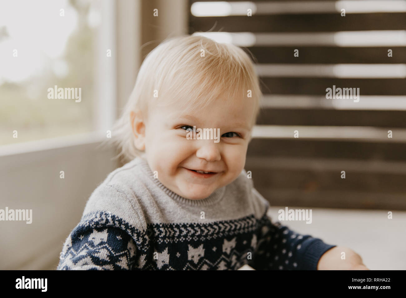 Cute Adorable petite blonde tout-petit enfant rire, s'amuser, et faire face à l'extérieur à la maison stupide sur le Patio porche blindé Banque D'Images