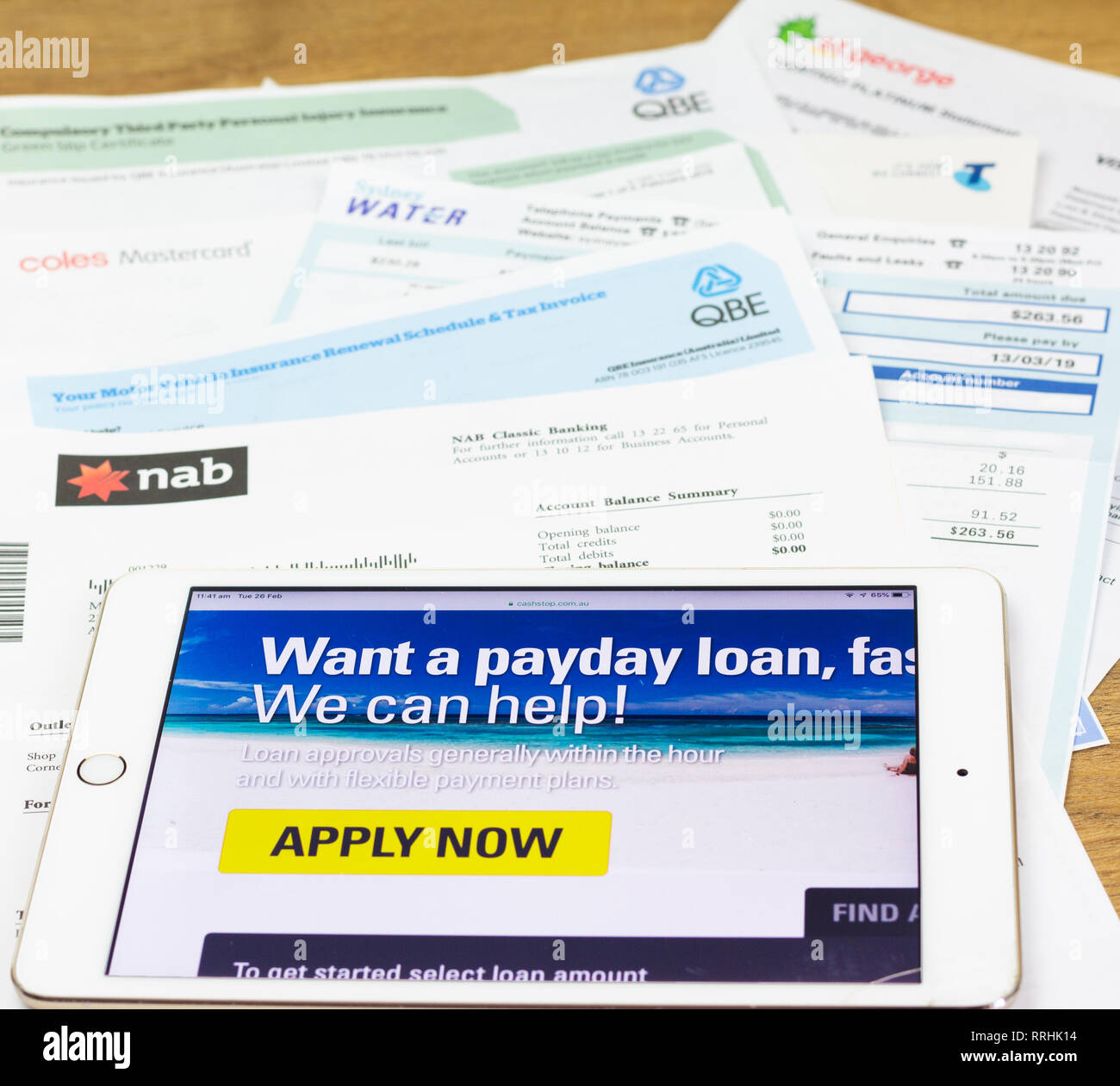 L'iPad et les Australiens à payer au prêteur de jour de payer des factures du ménage du site. À la dette a souligné les consommateurs se tournent vers les finances. Banque D'Images