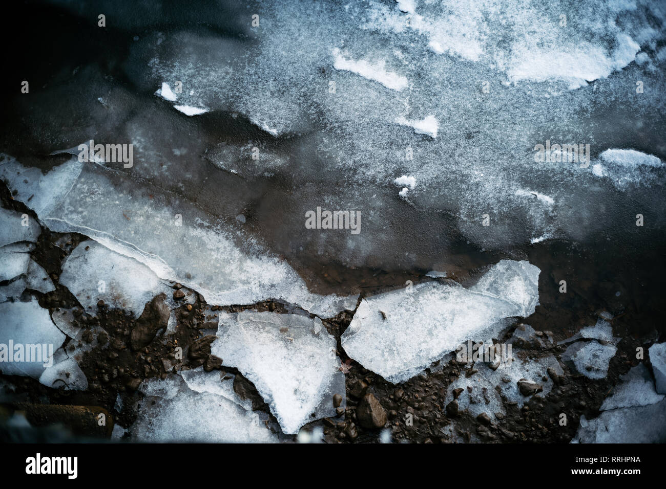 L'eau gelée et de glace glacial se fissure sous la pression le long d'une rive marina ligne à côté d'un quai. Banque D'Images