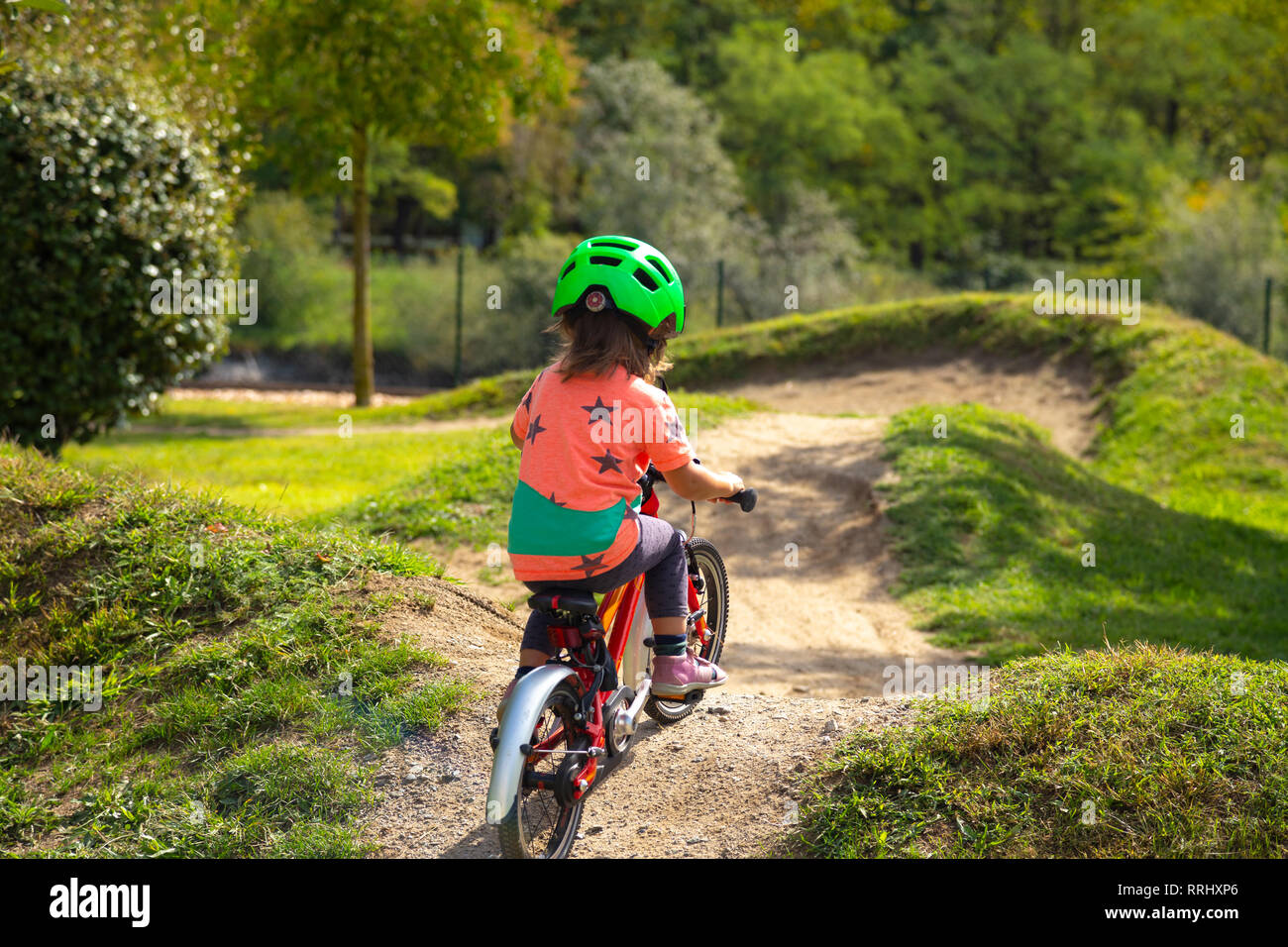 Petit enfant est de faire du vélo dans un parcours de vélo Banque D'Images Petit enfant est de faire du vélo dans un parcours de vélo Banque D'Images