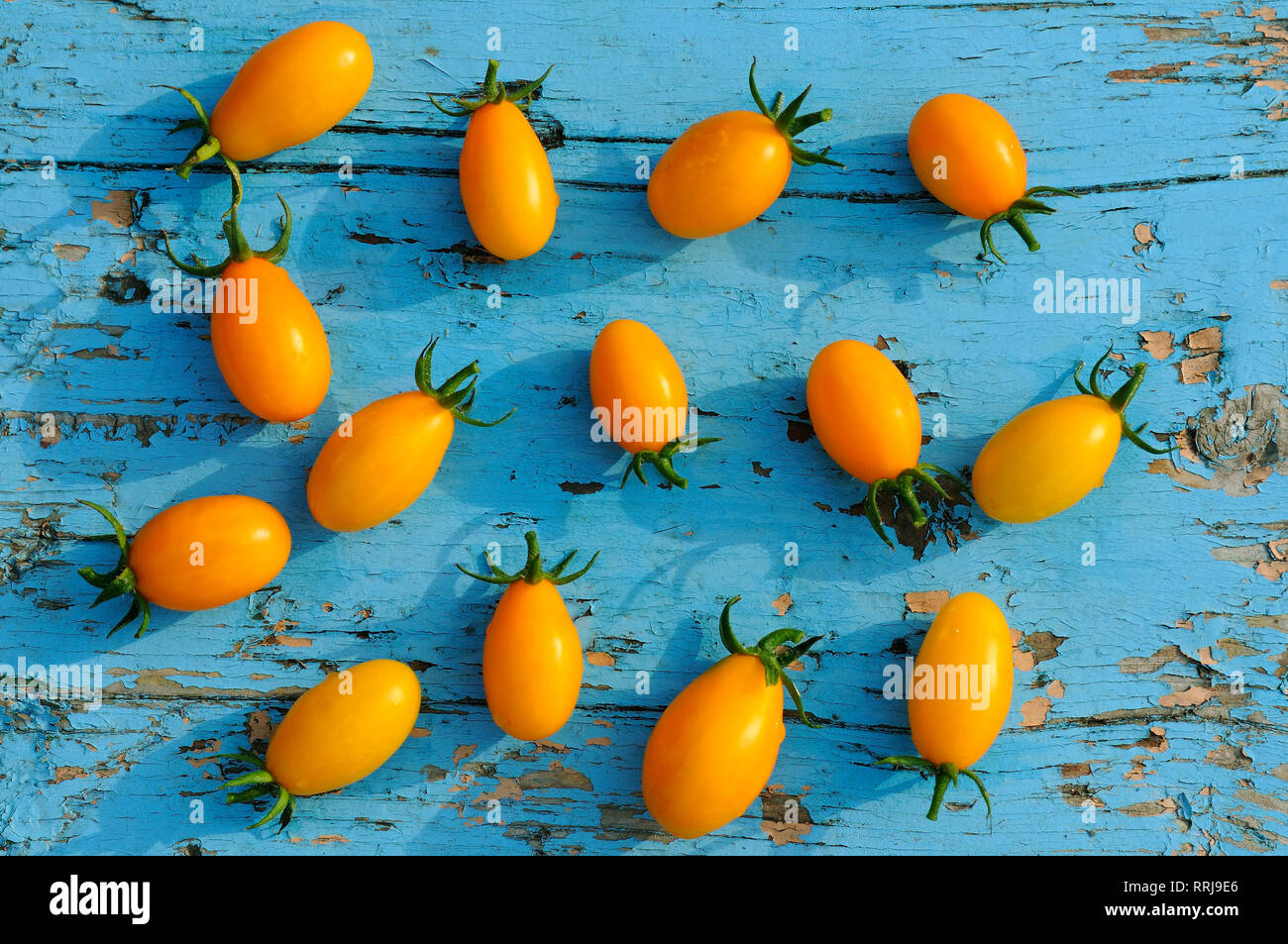 Petites tomates jaunes sur une surface en bois bleu Banque D'Images