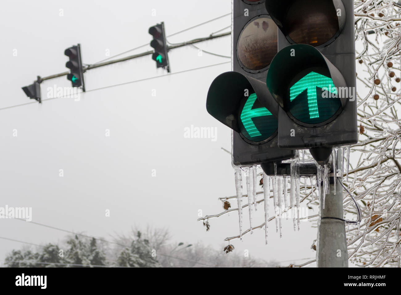 Feu vert pour l'avant, et les virages à gauche, avec les glaçons haging d'eux, pendant la saison d'hiver, après des jours de pluie se tourna vers la glace. Banque D'Images