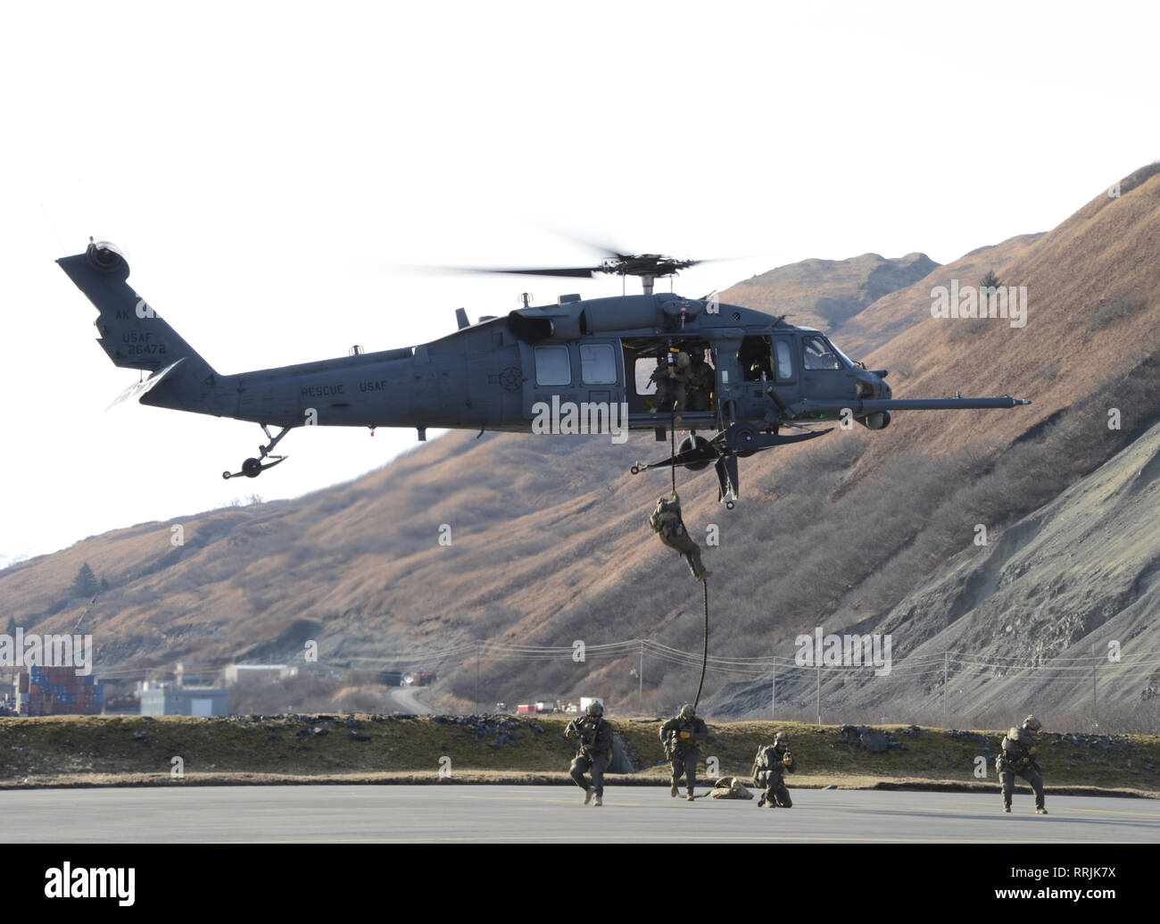 La Sécurité maritime de la Garde côtière canadienne les membres de l'équipe d'intervention rapide de l'Ouest en rappel d'un 176e Escadre, 210e Escadron de sauvetage en Alaska Air National Guard UH-60G Pave Hawk à Air Station Kodiak, en Alaska, le 22 février 2019, au cours d'un service commun d'entraînement. Les membres de l'ouest de l'outil MSRT maintenir une force d'alerte prêt à appuyer les commandants opérationnels de la Garde côtière canadienne et le ministère de la Défense, les commandants de combat pour les deux opérations à court préavis emergent et planifié les événements de sécurité. Photo de la Garde côtière des États-Unis par le Premier maître de Charly Hengen. Banque D'Images