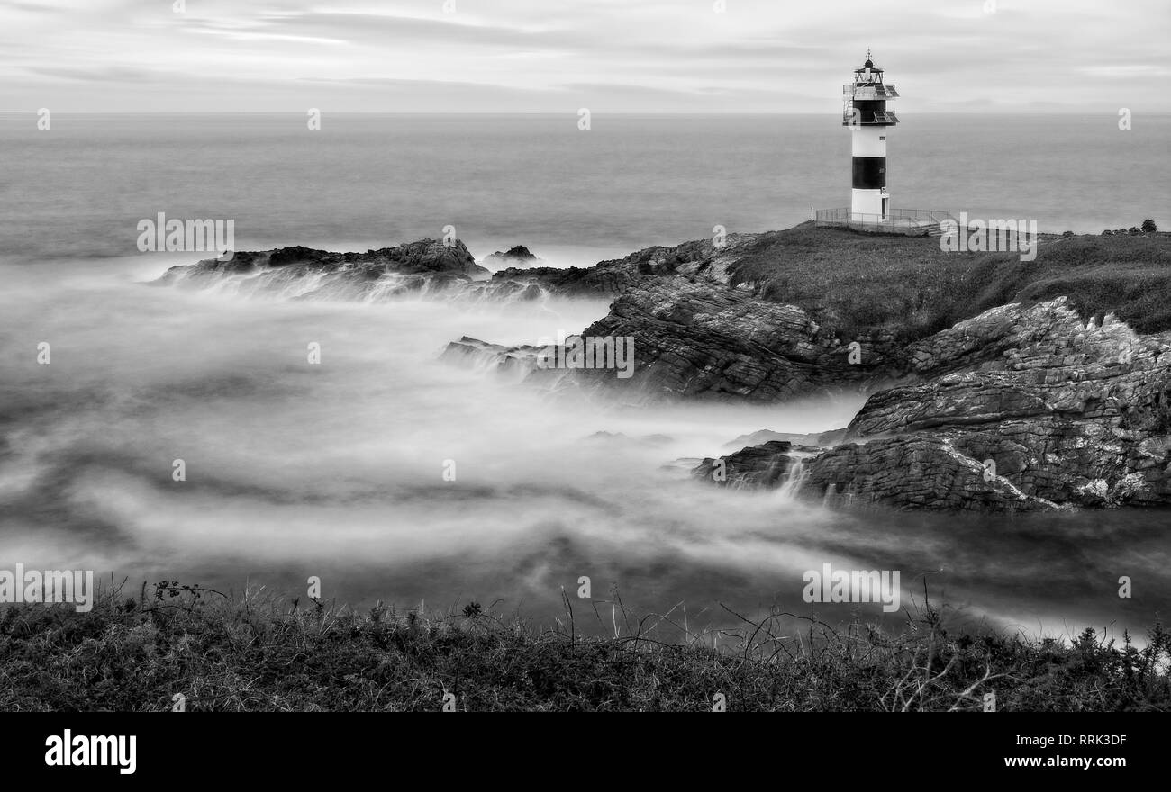 Île avec un phare avec le mouvement des vagues Banque D'Images