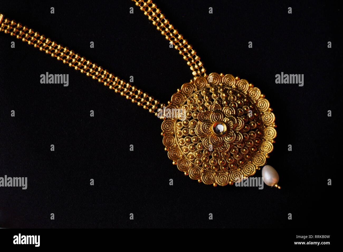 Collier d'or artificiel sur un fond noir Banque D'Images