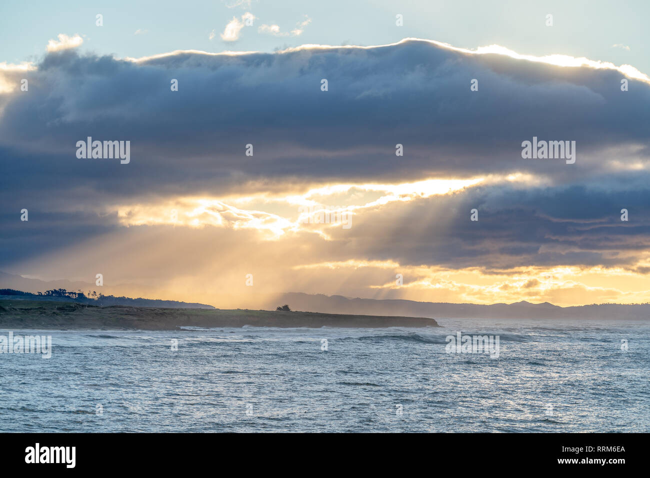 Au cours d'une partie des nuages lever du soleil le long de la côte californienne, pour créer des rayons de lumière à travers l'ocean spray. Banque D'Images